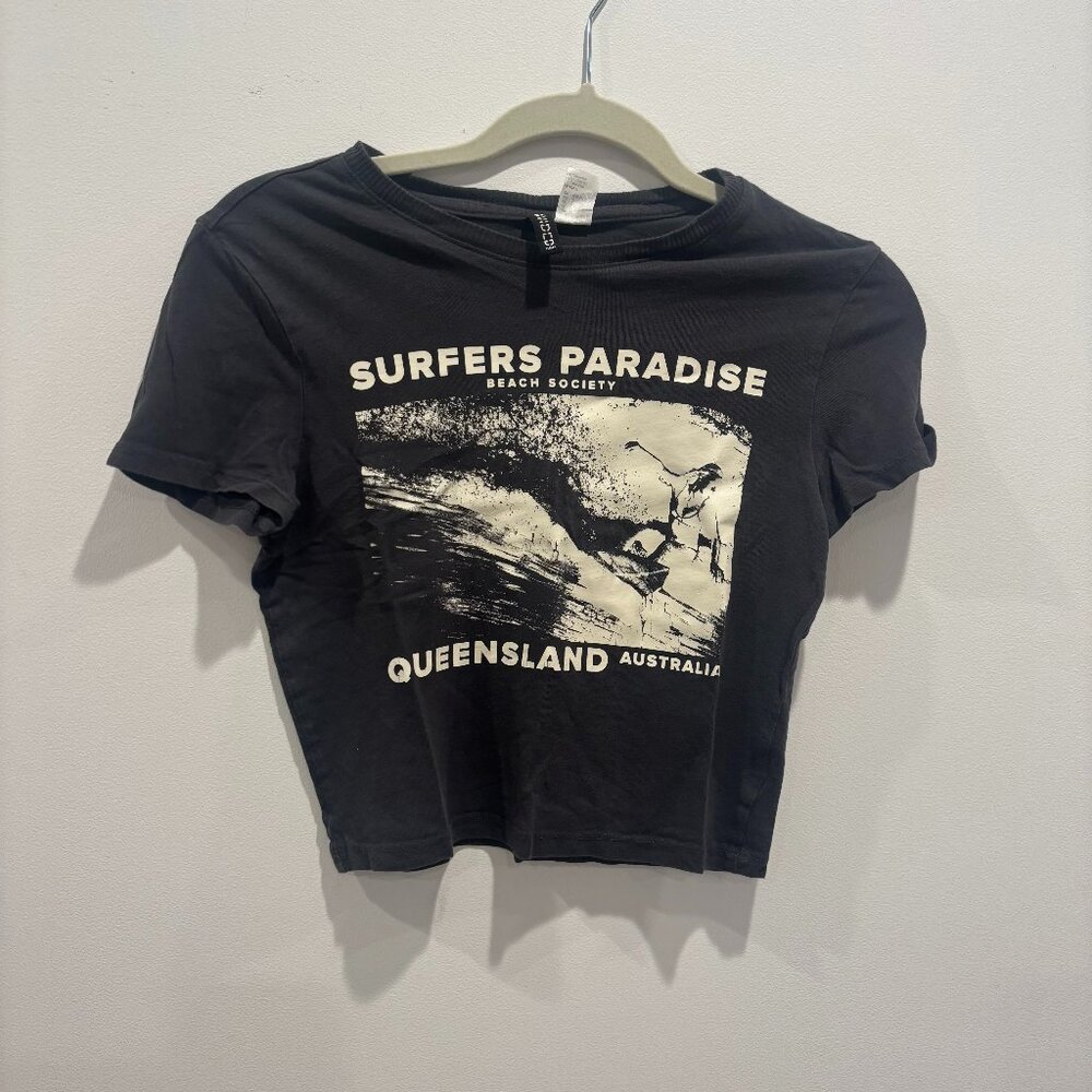 Dark grey baby tee with surfing design on the front